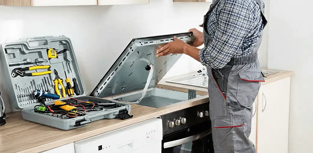 Handyman repairing a cooktop and checking wiring connections in Sarasota, FL
