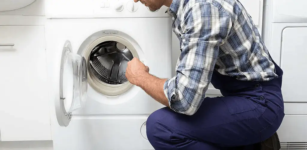 Handyman inspecting a dryer drum and internal parts for repair in Sarasota, FL