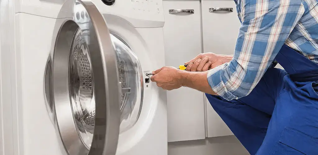 Handyman repairing a clothes dryer and checking electrical connections in Sarasota, FL