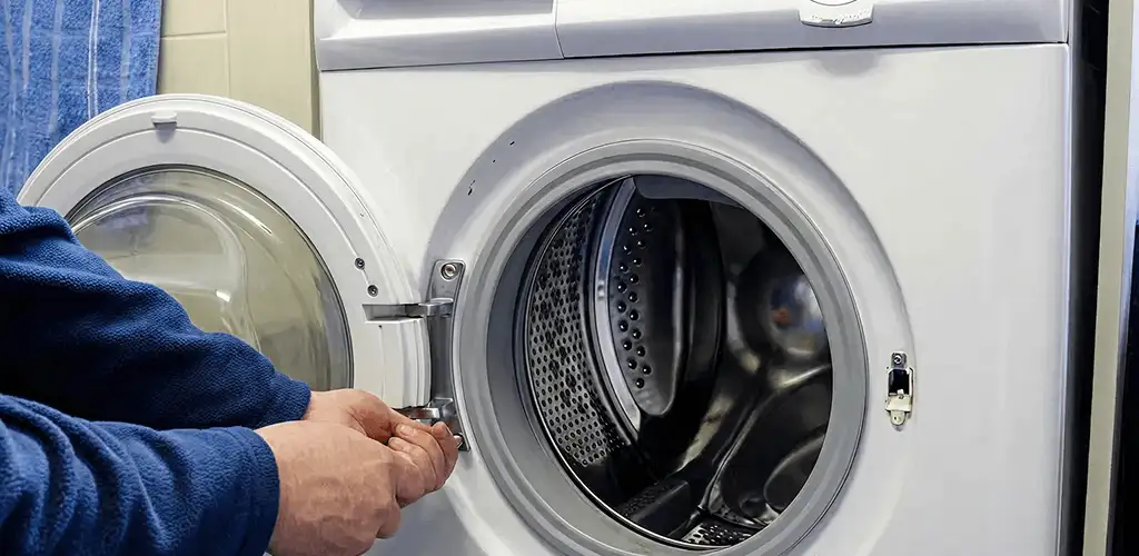 Washing machine repair handyman checking a front-load washer door and latch in Sarasota, FL